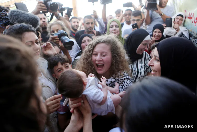 Palestinian activist and campaigner Ahed Tamimi carries a child in the West Bank village of Nabi Saleh near Ramallah on July 29, 2018, upon her release from prison after an eight-month sentence for slapping two Israeli s...