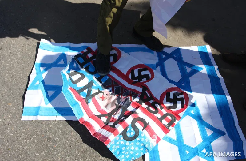 Palestinians burn an Israeli, British and U.S. flags during a protest to show solidarity with Palestinian prisoners held in Israeli jails, in front of Red cross office in Gaza city on July 30, 2018. Photo by Mahmoud Ajou...