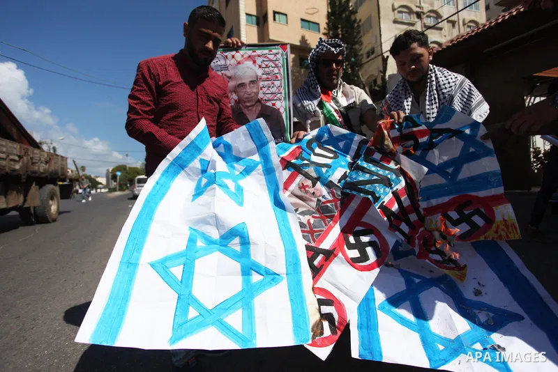 Palestinians burn an Israeli, British and U.S. flags during a protest to show solidarity with Palestinian prisoners held in Israeli jails, in front of Red cross office in Gaza city on July 30, 2018. Photo by Mahmoud Ajou...