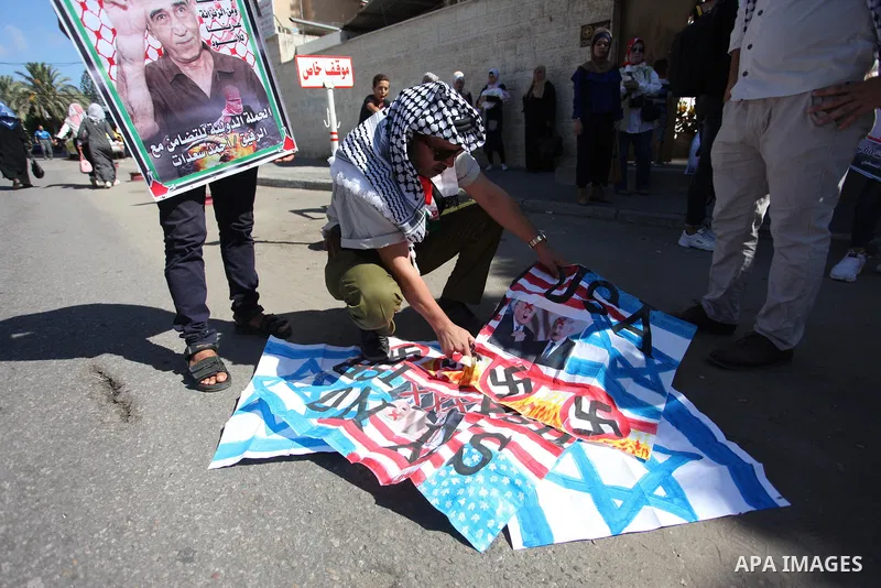 Palestinians burn an Israeli, British and U.S. flags during a protest to show solidarity with Palestinian prisoners held in Israeli jails, in front of Red cross office in Gaza city on July 30, 2018. Photo by Mahmoud Ajou...