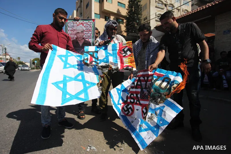 Palestinians burn an Israeli, British and U.S. flags during a protest to show solidarity with Palestinian prisoners held in Israeli jails, in front of Red cross office in Gaza city on July 30, 2018. Photo by Mahmoud Ajou...
