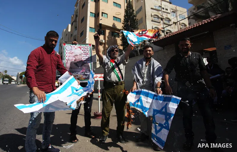 Palestinians burn an Israeli, British and U.S. flags during a protest to show solidarity with Palestinian prisoners held in Israeli jails, in front of Red cross office in Gaza city on July 30, 2018. Photo by Mahmoud Ajou...