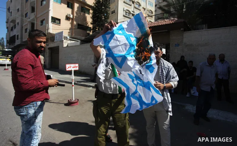 Palestinians burn an Israeli, British and U.S. flags during a protest to show solidarity with Palestinian prisoners held in Israeli jails, in front of Red cross office in Gaza city on July 30, 2018. Photo by Mahmoud Ajou...