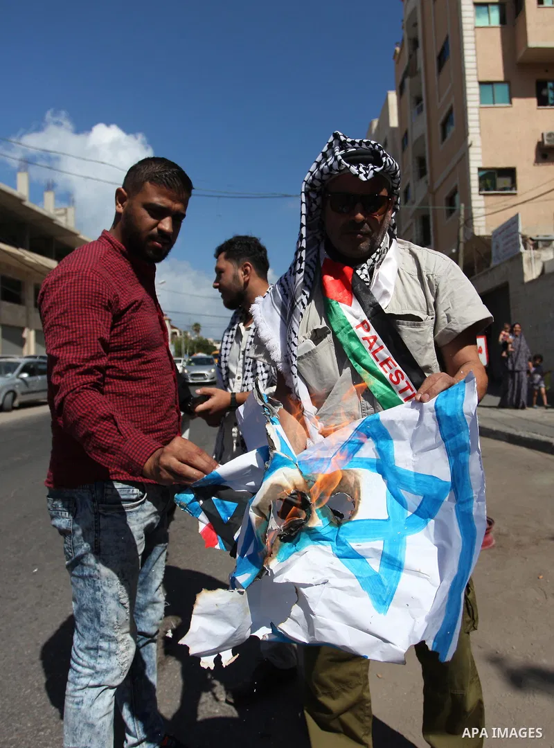 Palestinians burn an Israeli, British and U.S. flags during a protest to show solidarity with Palestinian prisoners held in Israeli jails, in front of Red cross office in Gaza city on July 30, 2018. Photo by Mahmoud Ajou...