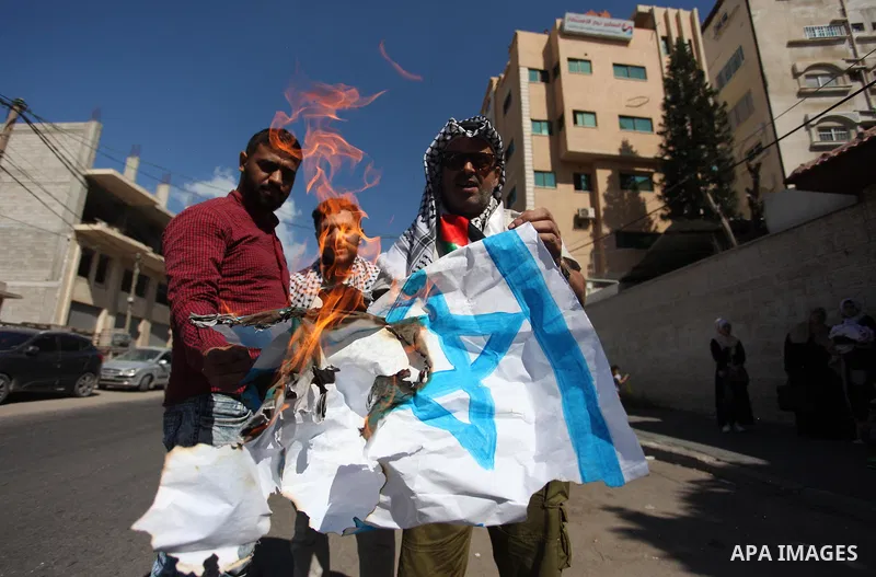 Palestinians burn an Israeli, British and U.S. flags during a protest to show solidarity with Palestinian prisoners held in Israeli jails, in front of Red cross office in Gaza city on July 30, 2018. Photo by Mahmoud Ajou...