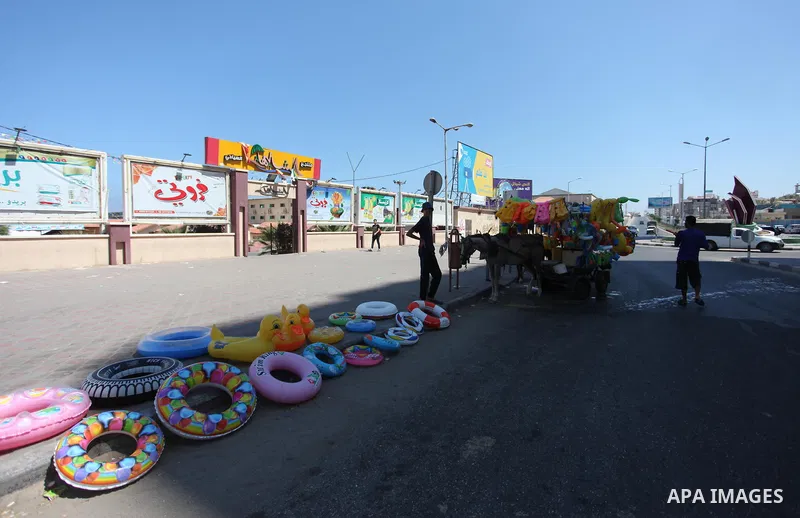 A Palestinian man displays summer games and tires at a street in Gaza city, on July 31, 2018. Photo by Mahmoud Ajour