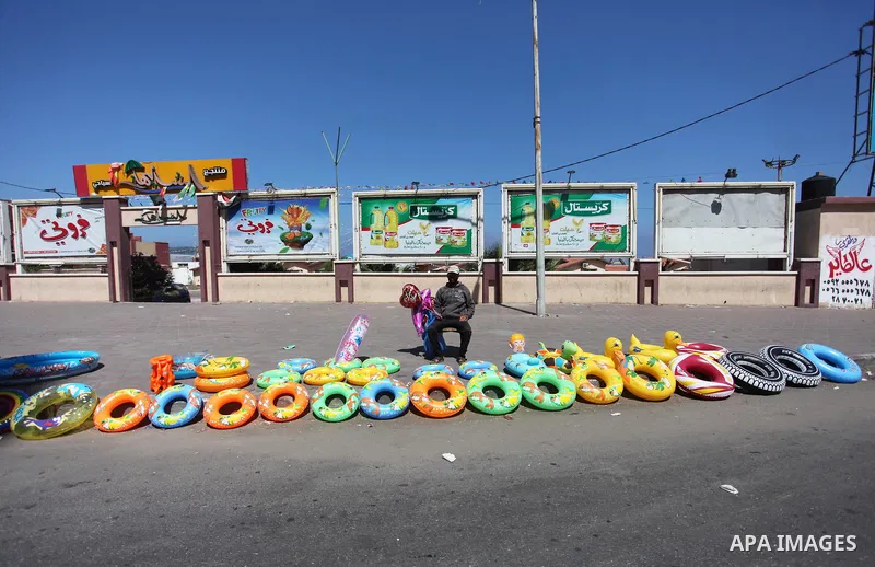 A Palestinian man displays summer games and tires at a street in Gaza city, on July 31, 2018. Photo by Mahmoud Ajour