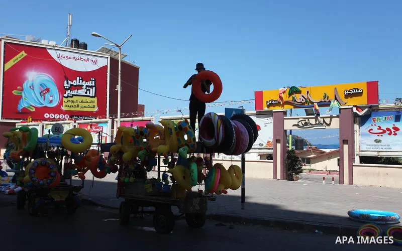 A Palestinian man displays summer games and tires at a street in Gaza city, on July 31, 2018. Photo by Mahmoud Ajour