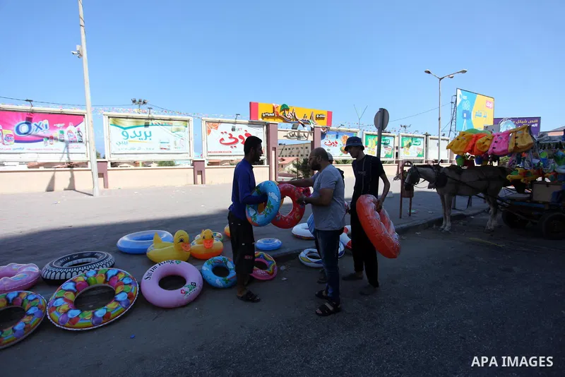 A Palestinian man displays summer games and tires at a street in Gaza city, on July 31, 2018. Photo by Mahmoud Ajour