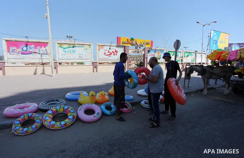 A Palestinian man displays summer games and tires at a street in Gaza city, on July 31, 2018. Photo by Mahmoud Ajour