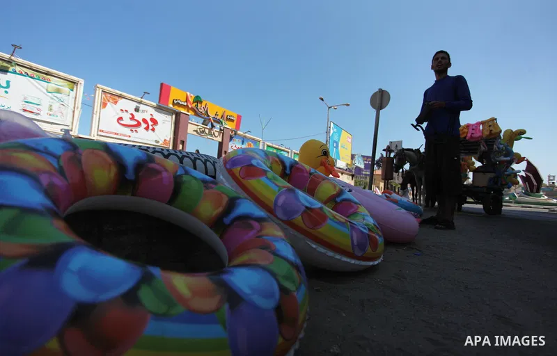 A Palestinian man displays summer games and tires at a street in Gaza city, on July 31, 2018. Photo by Mahmoud Ajour