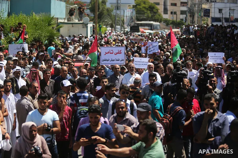 Palestinians hold banners during a demonstraion against a U.S. decision to cut aid, in front of the headquarters United Nations Relief and Works Agency (UNRWA), in Gaza City, on July 31, 2018. Photo by Ashraf Amra