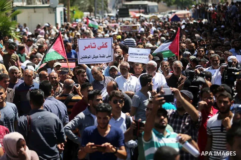 Palestinians hold banners during a demonstraion against a U.S. decision to cut aid, in front of the headquarters United Nations Relief and Works Agency (UNRWA), in Gaza City, on July 31, 2018. Photo by Ashraf Amra