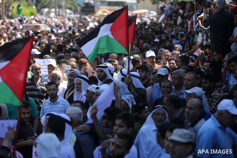Palestinians hold banners during a demonstraion against a U.S. decision to cut aid, in front of the headquarters United Nations Relief and Works Agency (UNRWA), in Gaza City, on July 31, 2018. Photo by Ashraf Amra