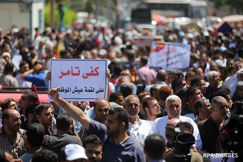 Palestinians hold banners during a demonstraion against a U.S. decision to cut aid, in front of the headquarters United Nations Relief and Works Agency (UNRWA), in Gaza City, on July 31, 2018. Photo by Ashraf Amra