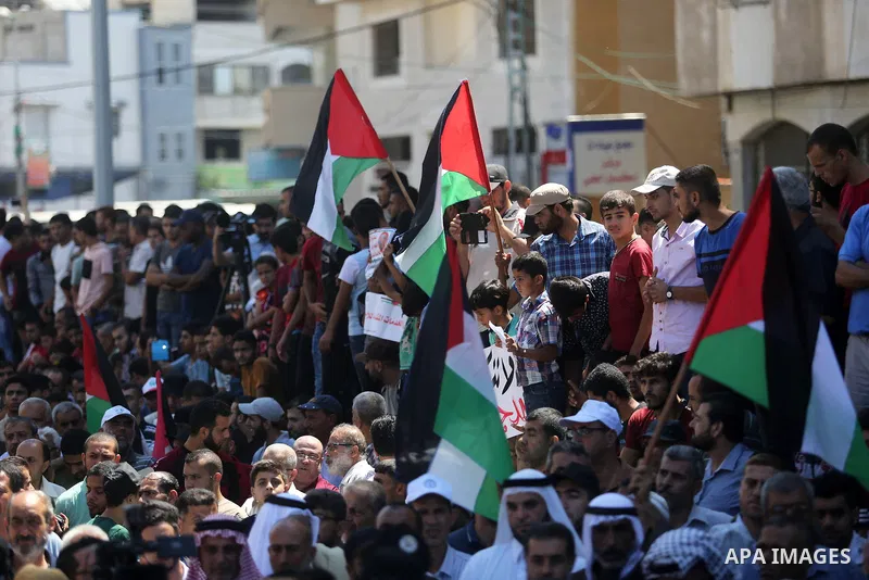 Palestinians hold banners during a demonstraion against a U.S. decision to cut aid, in front of the headquarters United Nations Relief and Works Agency (UNRWA), in Gaza City, on July 31, 2018. Photo by Ashraf Amra