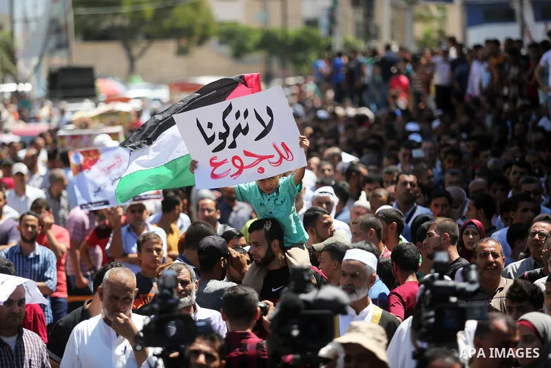 Palestinians hold banners during a demonstraion against a U.S. decision to cut aid, in front of the headquarters United Nations Relief and Works Agency (UNRWA), in Gaza City, on July 31, 2018. Photo by Ashraf Amra