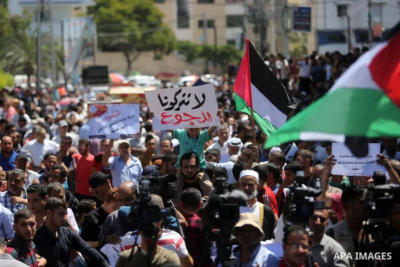 Palestinians hold banners during a demonstraion against a U.S. decision to cut aid, in front of the headquarters United Nations Relief and Works Agency (UNRWA), in Gaza City, on July 31, 2018. Photo by Ashraf Amra