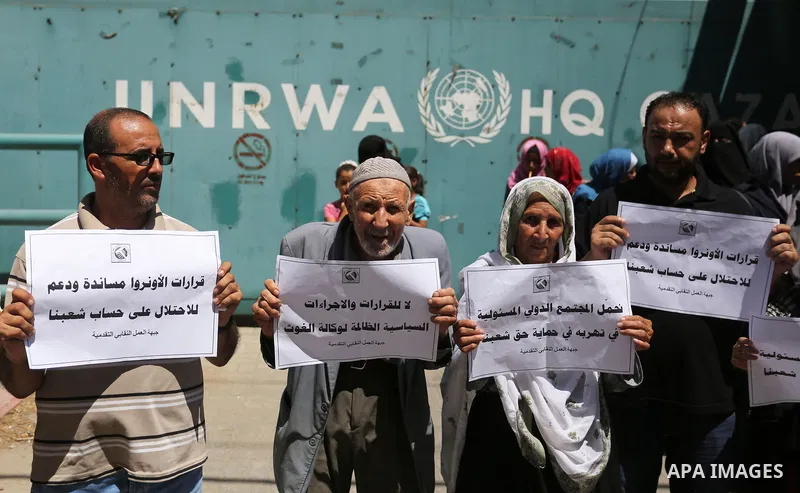 Palestinians hold banners during a demonstraion against a U.S. decision to cut aid, in front of the headquarters United Nations Relief and Works Agency (UNRWA), in Gaza City, on July 31, 2018. Photo by Ashraf Amra