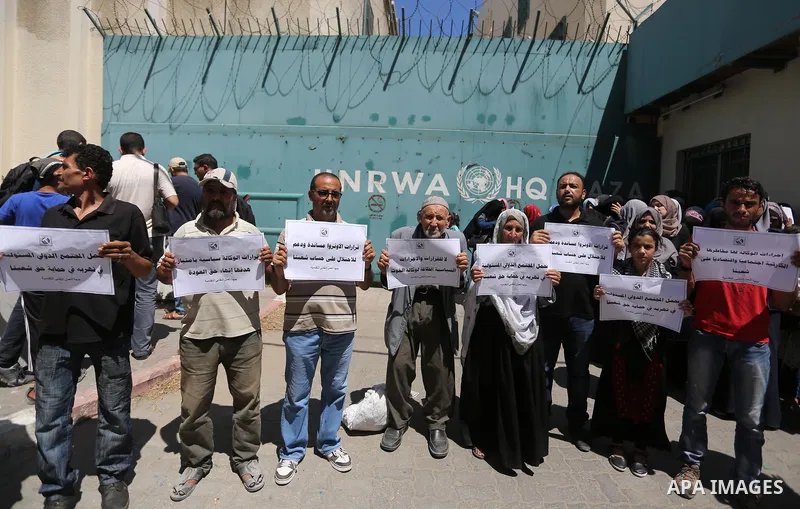 Palestinians hold banners during a demonstraion against a U.S. decision to cut aid, in front of the headquarters United Nations Relief and Works Agency (UNRWA), in Gaza City, on July 31, 2018. Photo by Ashraf Amra