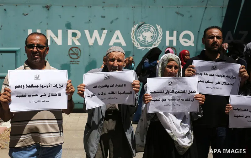 Palestinians hold banners during a demonstraion against a U.S. decision to cut aid, in front of the headquarters United Nations Relief and Works Agency (UNRWA), in Gaza City, on July 31, 2018. Photo by Ashraf Amra