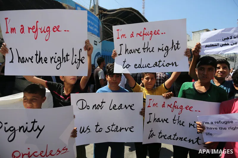 Palestinians hold banners during a demonstraion against a U.S. decision to cut aid, in front of the headquarters United Nations Relief and Works Agency (UNRWA), in Gaza City, on July 31, 2018. Photo by Ashraf Amra