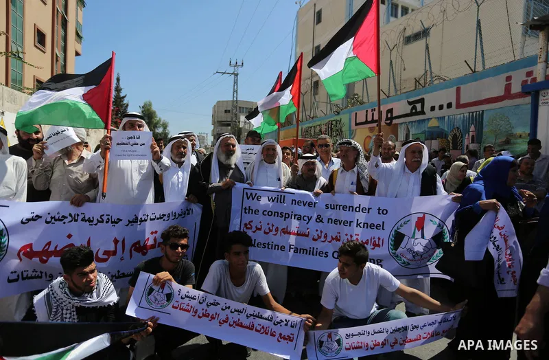 Palestinians hold banners during a demonstraion against a U.S. decision to cut aid, in front of the headquarters United Nations Relief and Works Agency (UNRWA), in Gaza City, on July 31, 2018. Photo by Ashraf Amra