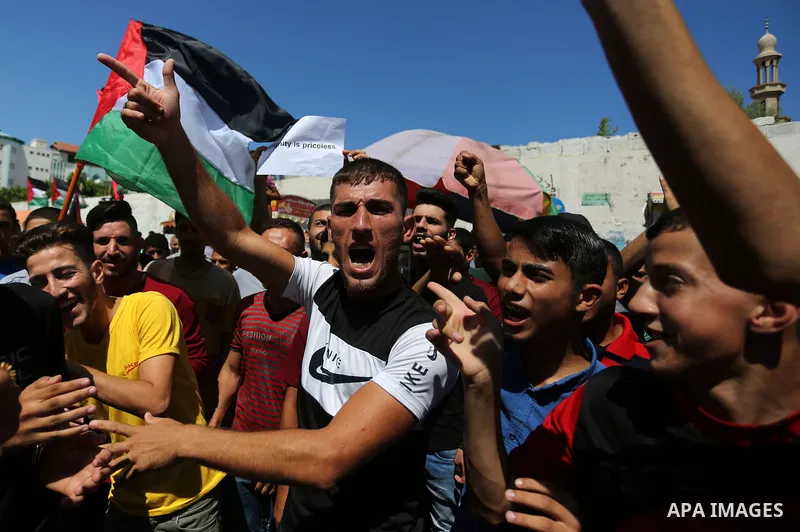 Palestinians hold banners during a demonstraion against a U.S. decision to cut aid, in front of the headquarters United Nations Relief and Works Agency (UNRWA), in Gaza City, on July 31, 2018. Photo by Ashraf Amra