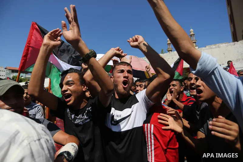 Palestinians hold banners during a demonstraion against a U.S. decision to cut aid, in front of the headquarters United Nations Relief and Works Agency (UNRWA), in Gaza City, on July 31, 2018. Photo by Ashraf Amra