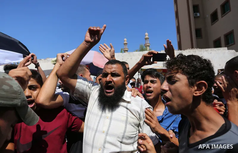 Palestinians hold banners during a demonstraion against a U.S. decision to cut aid, in front of the headquarters United Nations Relief and Works Agency (UNRWA), in Gaza City, on July 31, 2018. Photo by Ashraf Amra
