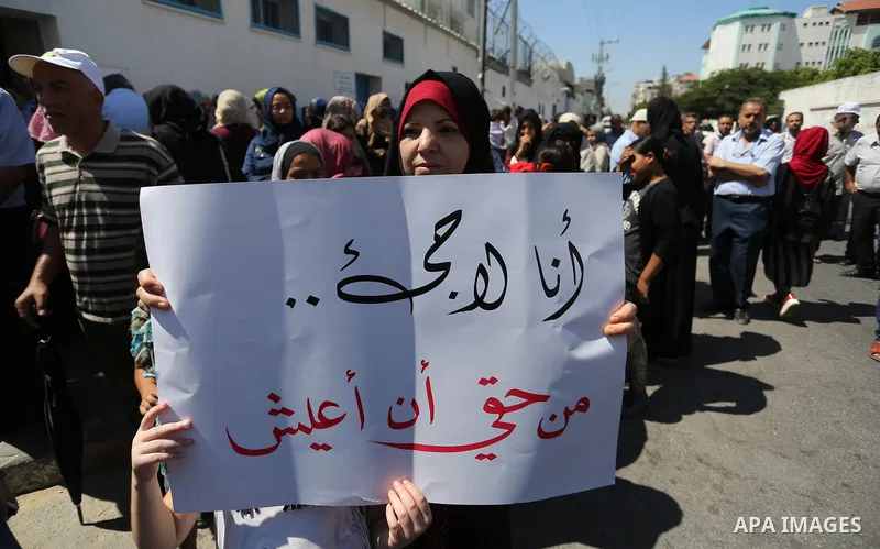 Palestinians hold banners during a demonstraion against a U.S. decision to cut aid, in front of the headquarters United Nations Relief and Works Agency (UNRWA), in Gaza City, on July 31, 2018. Photo by Ashraf Amra