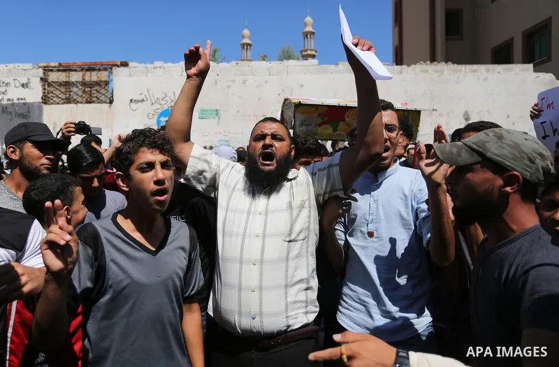 Palestinians hold banners during a demonstraion against a U.S. decision to cut aid, in front of the headquarters United Nations Relief and Works Agency (UNRWA), in Gaza City, on July 31, 2018. Photo by Ashraf Amra