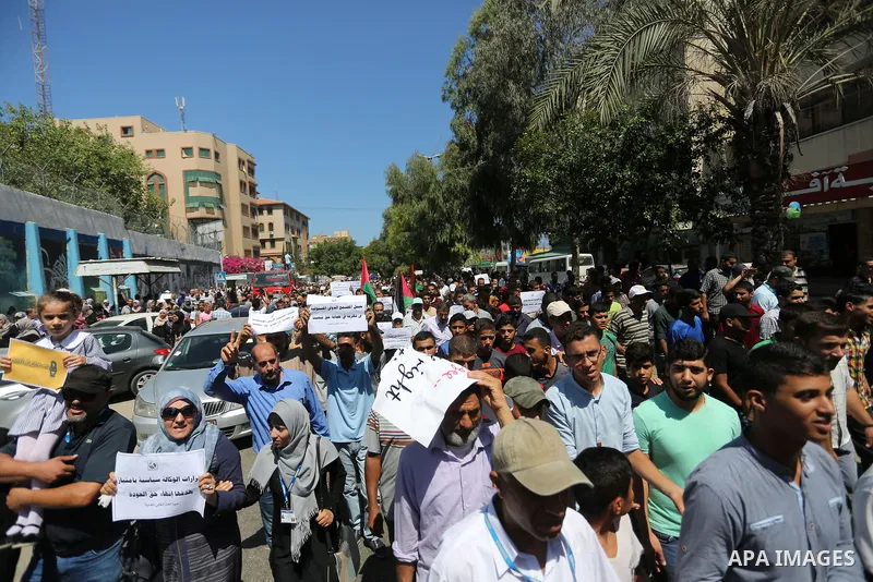 Palestinians hold banners during a demonstraion against a U.S. decision to cut aid, in front of the headquarters United Nations Relief and Works Agency (UNRWA), in Gaza City, on July 31, 2018. Photo by Ashraf Amra