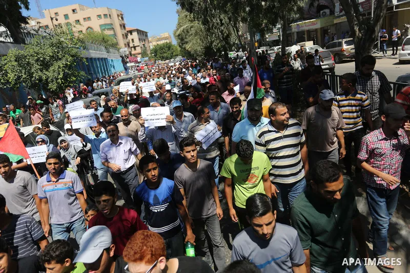Palestinians hold banners during a demonstraion against a U.S. decision to cut aid, in front of the headquarters United Nations Relief and Works Agency (UNRWA), in Gaza City, on July 31, 2018. Photo by Ashraf Amra