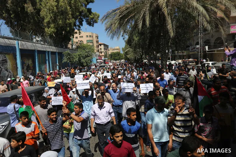 Palestinians hold banners during a demonstraion against a U.S. decision to cut aid, in front of the headquarters United Nations Relief and Works Agency (UNRWA), in Gaza City, on July 31, 2018. Photo by Ashraf Amra