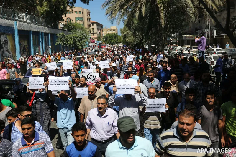 Palestinians hold banners during a demonstraion against a U.S. decision to cut aid, in front of the headquarters United Nations Relief and Works Agency (UNRWA), in Gaza City, on July 31, 2018. Photo by Ashraf Amra