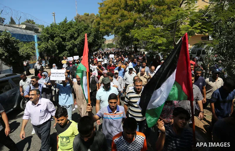 Palestinians hold banners during a demonstraion against a U.S. decision to cut aid, in front of the headquarters United Nations Relief and Works Agency (UNRWA), in Gaza City, on July 31, 2018. Photo by Ashraf Amra