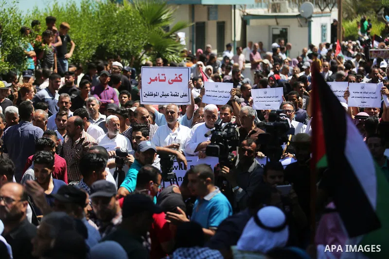 Palestinians hold banners during a demonstraion against a U.S. decision to cut aid, in front of the headquarters United Nations Relief and Works Agency (UNRWA), in Gaza City, on July 31, 2018. Photo by Ashraf Amra
