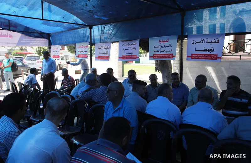 Palestinians take part in a protest to show solidarity with Palestinian prisoners are paid their salaries in Iseali jails at a tent in front of the Council of Ministers headcuarter in Gaza City, on Aug. 01, 2018. Photo b...