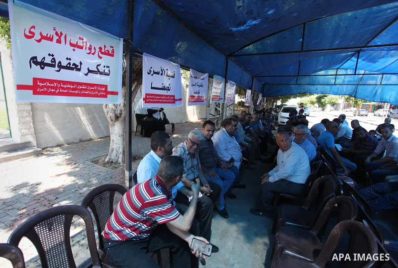 Palestinians take part in a protest to show solidarity with Palestinian prisoners are paid their salaries in Iseali jails at a tent in front of the Council of Ministers headcuarter in Gaza City, on Aug. 01, 2018. Photo b...