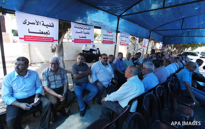 Palestinians take part in a protest to show solidarity with Palestinian prisoners are paid their salaries in Iseali jails at a tent in front of the Council of Ministers headcuarter in Gaza City, on Aug. 01, 2018. Photo b...