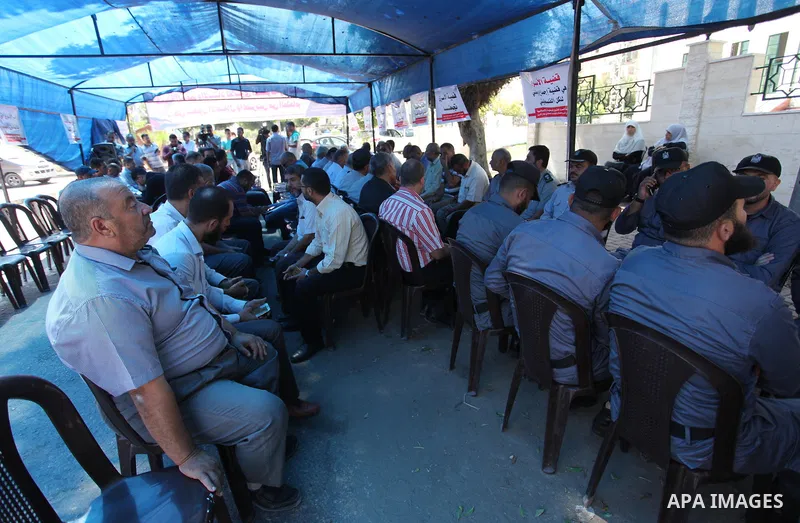 Palestinians take part in a protest to show solidarity with Palestinian prisoners are paid their salaries in Iseali jails at a tent in front of the Council of Ministers headcuarter in Gaza City, on Aug. 01, 2018. Photo b...