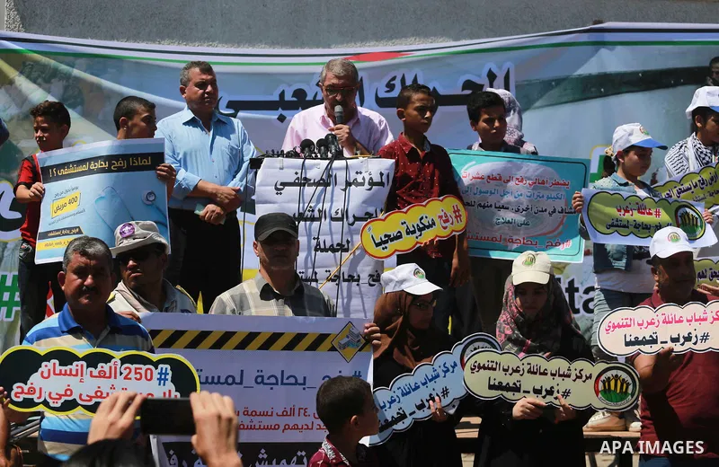Palestinians hold banners during a protest to demand the built of a hospital in Rafah in the southern Gaza strip on Aug. 01, 2018. Photo by Mahmoud Khattab