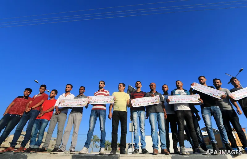 Palestinian hold placards during a protest to show solidarity with Palestinian employees of United Nations Relief and Works Agency against job cuts announced by the agency in Dair al Balah in the center of Gaza Strip on...