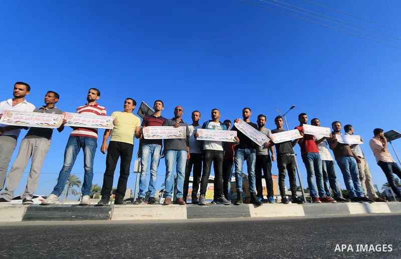 Palestinian hold placards during a protest to show solidarity with Palestinian employees of United Nations Relief and Works Agency against job cuts announced by the agency in Dair al Balah in the center of Gaza Strip on...