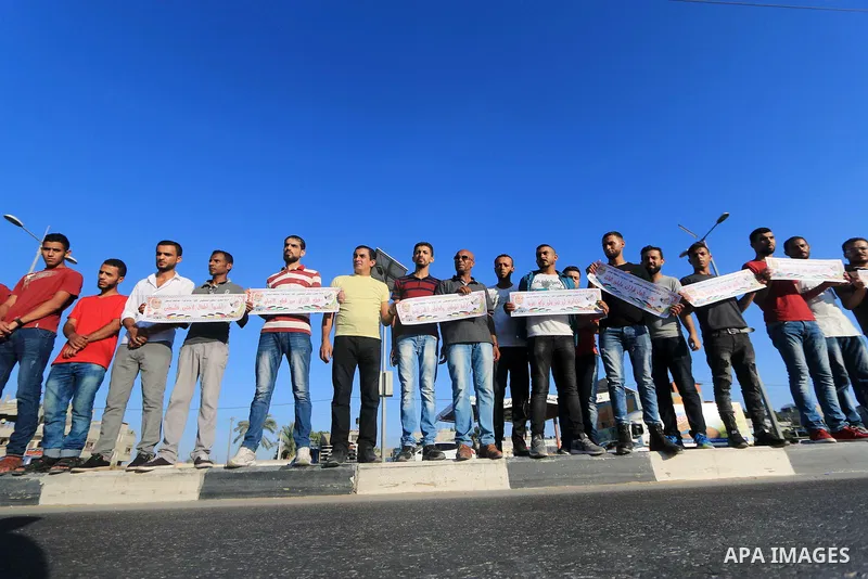 Palestinian hold placards during a protest to show solidarity with Palestinian employees of United Nations Relief and Works Agency against job cuts announced by the agency in Dair al Balah in the center of Gaza Strip on...