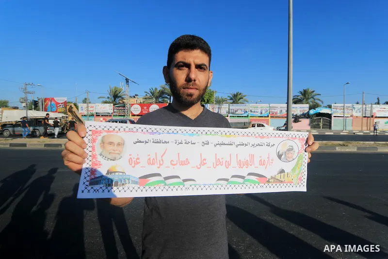 Palestinian hold placards during a protest to show solidarity with Palestinian employees of United Nations Relief and Works Agency against job cuts announced by the agency in Dair al Balah in the center of Gaza Strip on...