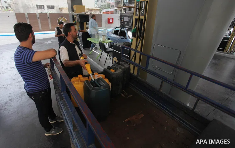 A Palestinian worker fills a container with gasoline at a gas station in Gaza city on Aug. 02, 2018. Israel reimposed a blockade of fuel supplies to Gaza on Thursday in response to a resurgence of the flow of fire kites...