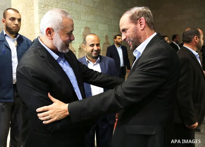 Palestinian Hamas Chief Ismail Haniyeh shakes hands with Hamas leader Hussam Badran, in Gaza City on August 2, 2018. Hamas Chief Media Office.