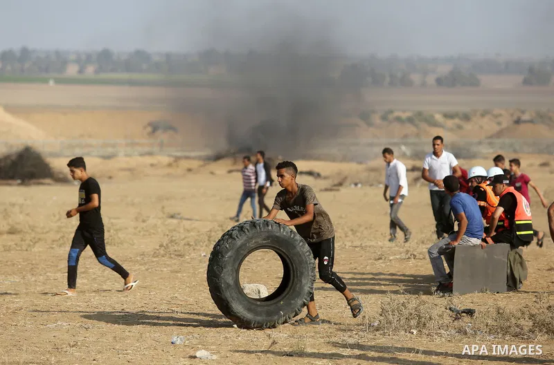 Palestinian protesters gather during clashes with Israeli troops in tents protest where Palestinian demand the right to return to their homeland at the Israel-Gaza border, in Khan Younis, in the southern Gaza Strip on Au...